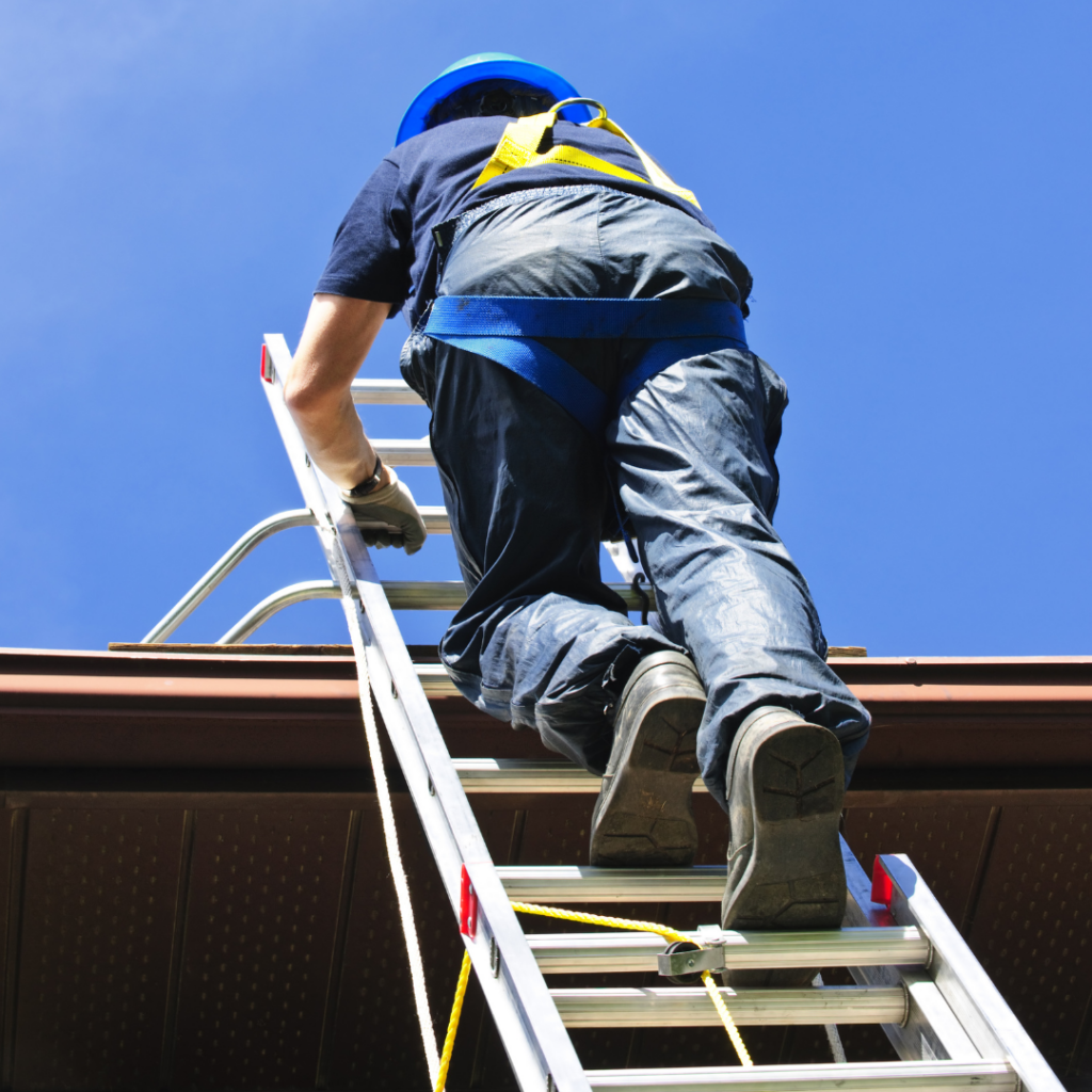Inspector climbing a ladder to check the roof of a two-story house in hollywood florida
